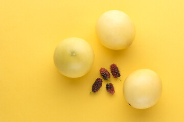 mulberries and passion fruits, ripe sweet fruits on a vibrant yellow background, closeup view taken from above