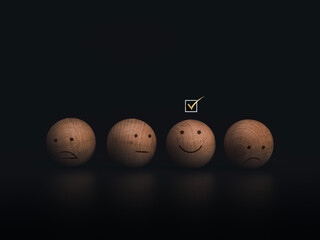 Check mark a checkbox on smiley emoticon face on the wooden balls on dark background. Customer service evaluation, rating, feedback, and satisfaction survey concept.
