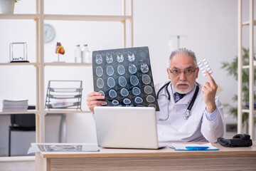 Old male doctor radiologist working in the clinic