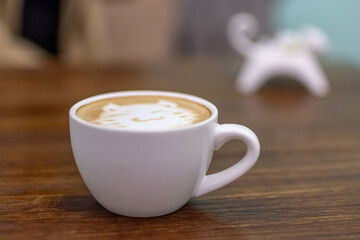 A cup of coffee and milk tea with a picture of a cat