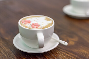 A cup of coffee and milk tea with a picture of a cat
