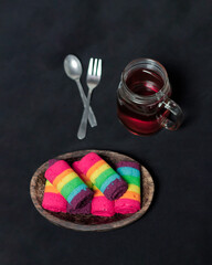 Sponge rolls consist of several colors forming a rainbow formation. Start your morning with a piece of sponge and warm tea. Sponge with a sweet taste and soft texture. Focus blur. Rainbow cake mockup.