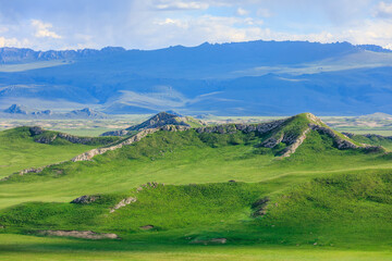 Fototapeta na wymiar Green grassland and mountain natural landscape in Xinjiang,China.Beautiful prairie scenery.