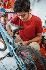 close up of young asian mechanic installing pedals using a wrench