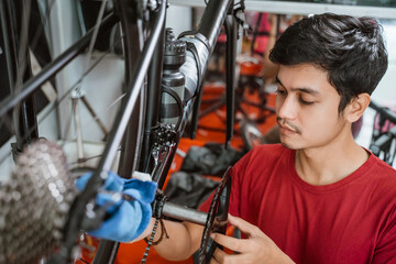 mechanic in red clothes working carefully assembling a bicycle crank set