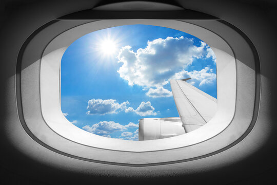 View of window airplane with wing and blue sky