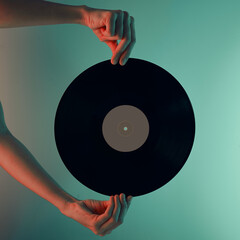 Woman hold retro vinyl disc in hands, toned photo. Vintage style 80s and 90s years