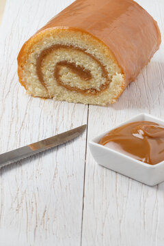 Brazilian rocambole of dulce de leche on white table.