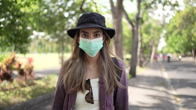 Coronavirus. Asian woman putting on a medical disposable mask to avoid viruses.