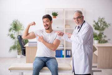 Fototapeta premium Young male patient visiting old male doctor