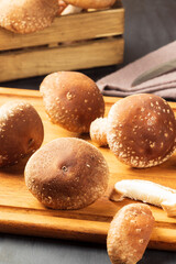 Fresh shiitake mushrooms on cutting board.