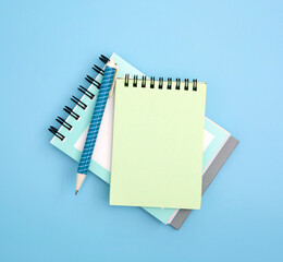 close up  spiral notepad with pen on  blue background , mockup for any text and message