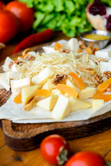 Cheese tasting with herbs and fruits on the rustic vintage table. Gerogian cuisine concept, traditional cheese platter.