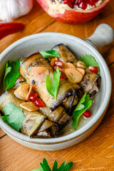 Healthy eggplant rolls stuffed with cheese served in a traditional bowl with a lot of fresh green.