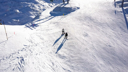 Aerial view of  People Skiing and snowboarding on hill, Ski Resort.
Drone flies over Skiers Skiing down the hill, Alp mountains, Val Thorens, France
