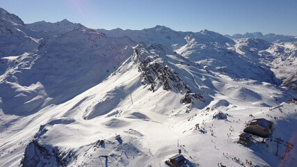 Aerial flight above stunning Alps Top Peak. 
Drone view above High mountain peaks sharp cliffs with blue sky , Val Thorens, France
