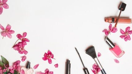 Flat lay composition with cosmetic products for makeup and pink apple flowers on a white background
