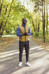 Obraz premium African american student walking in the park in autumn season