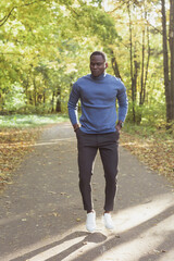 Obraz premium African american student walking in the park in autumn season