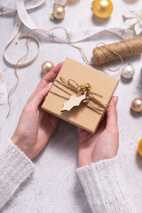 Female hands are holding Christmas gift box. Preparing for Christmas and New Years.