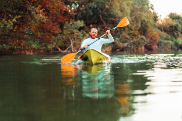 Kayaking on the river. Adult caucasian bearded man floating at the kayak. Copy space. The concept of the World Tourism Day