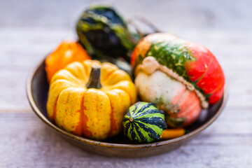 Autumn decorative pumpkins in the vintage bowl.