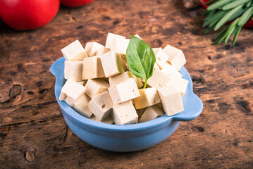 Diced tofu cheese in a blue bowl, close-up
