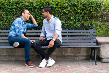 latin couple gay men sitting on a bench, gay concept