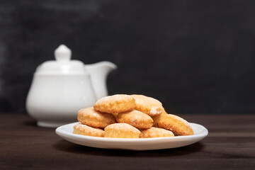 Shortbread cookies on white plate on wooden table, side view. Baking for tea, Fresh pastry