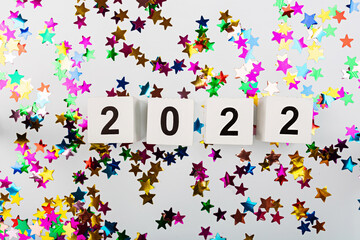 Happy new year 2022 background. Metallic balloons rainbow colors on white with confetti. Flat lay, top view, mockup, overhead. Winter holiday celebration
