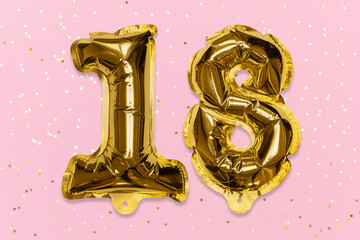 The number of the balloon made of golden foil, the number eighteen on a pink background with sequins. Birthday greeting card with inscription 18. Numerical digit, Celebration event, template.