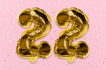 The number of the balloon made of golden foil, the number twenty two on a pink background with sequins. Birthday greeting card with inscription 22. Numerical digit, Celebration event, template.