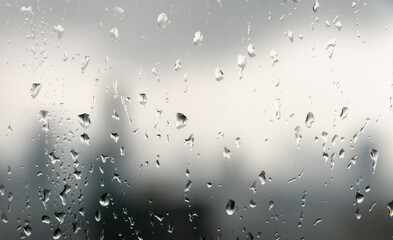 Rain droplets on a window with the Bangkok city skyline in the background
