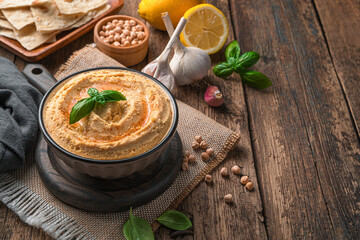 Oriental hummus with sesame, lemon and garlic on a wooden background. It is used as an appetizer or side dish.