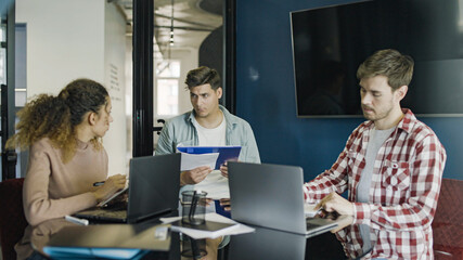 Obraz premium Team leader talking to software developers in office, modern technology, meeting