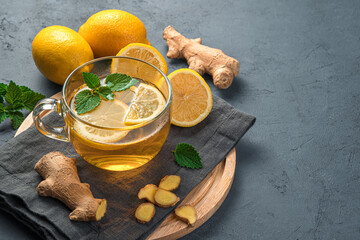 Hot tea with lemon and ginger on a graphite background. A useful, immune-boosting drink.