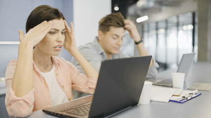 Two stressed office workers having a problem with project, not meeting a deadline