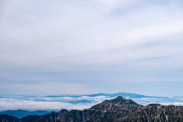 Fototapeta na wymiar 夕暮れ間近の南岳より笠ヶ岳と、その先に雲海に浮かぶ白山を撮影