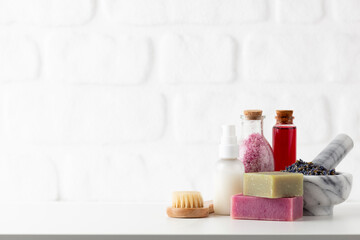 Cosmetics bottles and natural handmade soap on white background