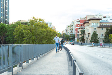 young african american executive man with briefcase drinking coffee while walking through the city