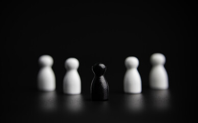 concept of successful leadership and teamwork, strategic planning. show by different colored wooden figurines on black background. with copy space