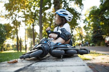 Selective focus on rollerskates young boy is wearing, resting in the park