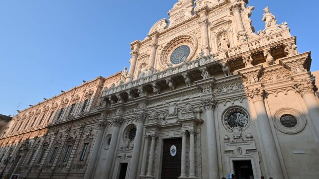 Lecce, Puglia, Italy. August 2021. The church of Santa Croce is the finest example of Lecce baroque. The pan footage displays it in all its beauty with late afternoon light.