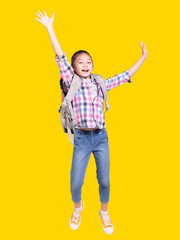Full length portrait of a happy student girl with bag and jumping.Isolated on yellow background.