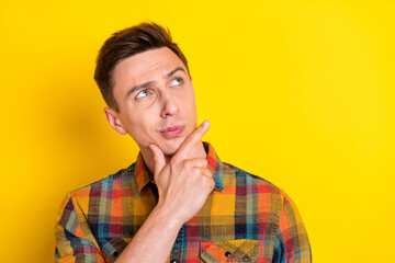 Portrait of attractive minded suspicious guy thinking touching chin copy space isolated over bright yellow color background © deagreez