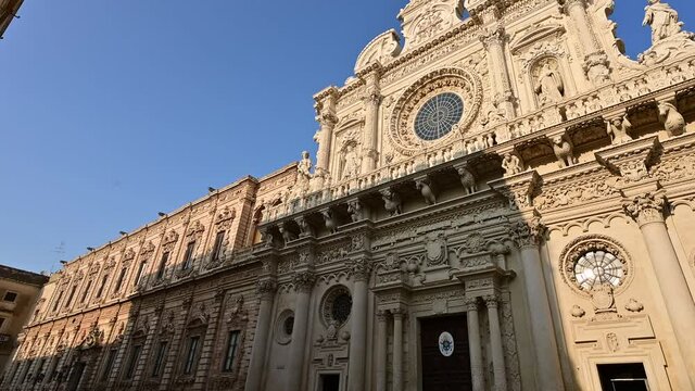Lecce, Puglia, Italy. August 2021. The church of Santa Croce is the finest example of Lecce baroque. The pan footage displays it in all its beauty with late afternoon light.