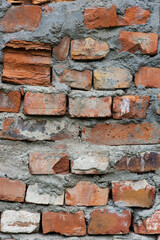 Lot of bricks in the wall and between them thick layers of cement close-up vertical orientation