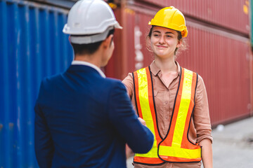 Professional two engineer container cargo foreman in helmets working standing and using walkie talkie checking stock into container for loading.logistic transport and business industry export