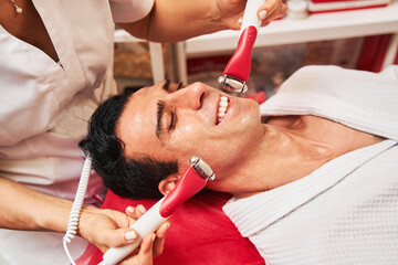 Man enjoying electric stimulation procedure in spa