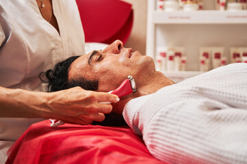 Obraz na płótnie Canvas Facial skin care massage with microcurrent tool